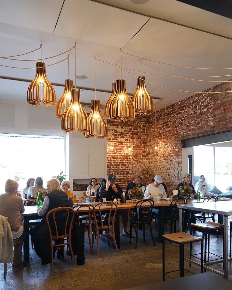 Timber pendant lights and exposed brick over a busy morning at Olie and Ari